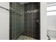 Contemporary tiled shower with glass doors, a rainfall showerhead, and pebble flooring at 2840 S Shade Ave, Sarasota, FL 34239