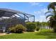 Lush backyard landscaping with a screened in patio, water views, and manicured lawn at 2918 130Th E Ave, Parrish, FL 34219