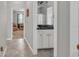 Hallway leading to bathroom with granite vanity, white cabinets, and neutral decor, offering a clean aesthetic at 2918 130Th E Ave, Parrish, FL 34219