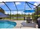 Screened-in pool deck with dining set and lake views at 2918 130Th E Ave, Parrish, FL 34219