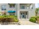 Well maintained exterior with white walls, balcony, blue awning, and vibrant green shrubs at 304 108Th W St, Bradenton, FL 34209