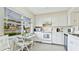 Kitchen has white cabinets and modern appliances with a lovely breakfast nook with a water view at 304 108Th W St, Bradenton, FL 34209