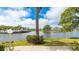 Lake view of community buildings and tall palm trees under a blue sky with white clouds at 304 108Th W St, Bradenton, FL 34209
