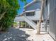 Coastal home exterior featuring a staircase leading to the elevated living space and lush landscaping at 3201 Casey Key Rd, Nokomis, FL 34275