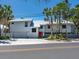 Coastal home features a red front door and is surrounded by swaying palm trees at 3201 Casey Key Rd, Nokomis, FL 34275