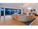 Bright living room featuring a large sectional sofa, hardwood floors, and ocean views through expansive windows at 3201 Casey Key Rd, Nokomis, FL 34275
