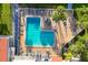 Aerial view of a well-maintained community pool with lounge chairs and umbrellas for relaxation at 3251 Beneva Rd # 104, Sarasota, FL 34232