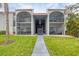 Condo building with stucco exterior, red tile roof, and open balconies overlooking a green lawn at 3251 Beneva Rd # 104, Sarasota, FL 34232