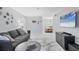 Inviting living room with plush rug, gray sofa, modern decor, and open access to dining area at 3251 Beneva Rd # 104, Sarasota, FL 34232