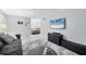 Inviting living room flows into dining area; features tile floors, modern decor, and a large TV at 3251 Beneva Rd # 104, Sarasota, FL 34232