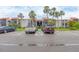 Community parking lot with various vehicles and buildings with red tiled roofs in the background on a sunny day at 3251 Beneva Rd # 104, Sarasota, FL 34232