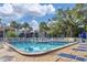 Community pool with lounge chairs, surrounded by lush greenery, perfect for soaking up the sun at 3251 Beneva Rd # 104, Sarasota, FL 34232