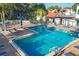 Community pool offers ample space for swimming and sunbathing with surrounding lounge chairs and greenery at 3251 Beneva Rd # 104, Sarasota, FL 34232
