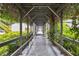 Shaded walkway covered in greenery, leading to residences, enhancing curb appeal and outdoor living experience at 3251 Beneva Rd # 104, Sarasota, FL 34232
