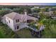 Back exterior aerial view showcasing a private backyard with a pool, lush landscaping, and a covered patio at 3432 Founders Club Dr, Sarasota, FL 34240