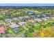 Panoramic aerial showcasing community homes and golf course with beautiful blue lakes in the background at 3432 Founders Club Dr, Sarasota, FL 34240