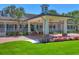 Elegant clubhouse entrance featuring a porte cochere, classic architecture, and colorful flower beds at 3432 Founders Club Dr, Sarasota, FL 34240