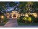 Elegant home exterior with lush landscaping, brick driveway, and inviting entrance at twilight at 3432 Founders Club Dr, Sarasota, FL 34240