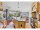 Bright kitchen with granite island, hardwood floors, and view to the pool area at 3432 Founders Club Dr, Sarasota, FL 34240