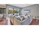 Bright living room with a large sectional sofa, opening to an outdoor pool area with lush landscaping at 3432 Founders Club Dr, Sarasota, FL 34240