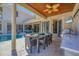 Outdoor kitchen featuring a dining table with seating, a TV, and views of the swimming pool and patio at 3432 Founders Club Dr, Sarasota, FL 34240