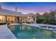 Stunning outdoor pool area with a hot tub, covered patio, and elegant landscaping at sunset at 3432 Founders Club Dr, Sarasota, FL 34240