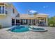 Backyard patio area includes a swimming pool, spa, covered outdoor kitchen, and a manicured lawn at 3432 Founders Club Dr, Sarasota, FL 34240
