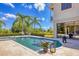 Beautiful swimming pool with a clear blue water and lush landscaping, surrounded by a stone deck and garden at 3432 Founders Club Dr, Sarasota, FL 34240