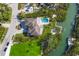 Aerial view of a beautiful home with a pool, lush landscaping, and waterfront access with a boat dock at 3465 Gulfmead Dr, Sarasota, FL 34242