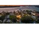Scenic aerial view of a waterfront neighborhood with boats on the water and stunning sunset at 3465 Gulfmead Dr, Sarasota, FL 34242