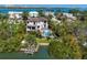 Aerial view of property with pool, lush trees, waterway, and boat lift providing waterfront access at 3465 Gulfmead Dr, Sarasota, FL 34242