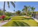 Lush backyard with waterfront access, a private dock, vibrant tropical foliage, and well-manicured landscaping at 3465 Gulfmead Dr, Sarasota, FL 34242