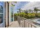 Balcony view overlooking tropical greenery, pool and beautiful blue sky at 3465 Gulfmead Dr, Sarasota, FL 34242