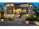 Beautiful home exterior with a three-car garage and manicured landscaping lit up at night at 3465 Gulfmead Dr, Sarasota, FL 34242