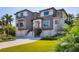 Elegant home featuring a well-manicured lawn, three-car garage, and beautiful front facade at 3465 Gulfmead Dr, Sarasota, FL 34242