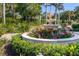 Beautiful lush garden with a stone fountain surrounded by bright colorful flowers and green foliage at 3465 Gulfmead Dr, Sarasota, FL 34242