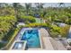 Aerial view of a sparkling pool and spa surrounded by lush landscaping and a canal at 3465 Gulfmead Dr, Sarasota, FL 34242