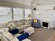 Cozy living room featuring comfortable seating, a faux fireplace, and soft natural light at 3710 Gulf Of Mexico Dr # A20, Longboat Key, FL 34228