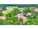 An aerial view of the roof and surrounding landscape including a lake, a golf course, and plenty of mature trees at 3916 Chatsworth Greene # 3, Sarasota, FL 34235