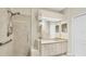 Bright bathroom featuring a tiled walk-in shower, a large mirror, and built in cabinetry at 3916 Chatsworth Greene # 3, Sarasota, FL 34235