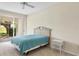 Well-lit bedroom with neutral carpet, a queen bed, side table, and sliding glass doors with a view of the yard at 3916 Chatsworth Greene # 3, Sarasota, FL 34235