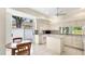 Bright kitchen featuring white cabinetry, an island, white appliances, and a sliding door leading to a private courtyard at 3916 Chatsworth Greene # 3, Sarasota, FL 34235