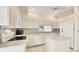 Open kitchen features white cabinets, an island, white appliances, and a window overlooking the back yard at 3916 Chatsworth Greene # 3, Sarasota, FL 34235