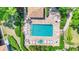 Aerial view of the community pool surrounded by lounge chairs, greenery, and a brick-paved deck at 3916 Chatsworth Greene # 3, Sarasota, FL 34235
