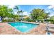 Community pool surrounded by lush landscaping, lounge chairs, and seating areas at 3916 Chatsworth Greene # 3, Sarasota, FL 34235
