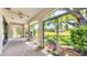 Bright sunroom with large windows offering picturesque views of the lush green lawn and mature trees at 3916 Chatsworth Greene # 3, Sarasota, FL 34235