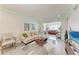 Bright living room features light-colored furniture and updated tile flooring at 4186 Heron Way # B-219, Bradenton, FL 34205