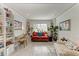 Comfortable living room featuring a red sofa, desk, and ample natural light at 4186 Heron Way # B-219, Bradenton, FL 34205