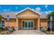 Exterior of the clubhouse featuring a grand entrance with double doors, columns, and manicured landscaping at 4225 Overture Cir, Bradenton, FL 34209