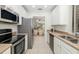 Contemporary kitchen design with stainless steel appliances and an open view to the living spaces at 4225 Overture Cir, Bradenton, FL 34209